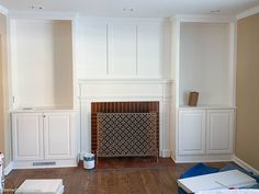 an empty living room with white painted walls and wood flooring, including a fireplace