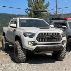 two toyota trucks parked on the side of a mountain