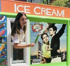 a woman standing in front of an ice cream vending machine with pictures on it