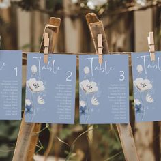 there are three signs that say the table numbers and place cards on easel holders