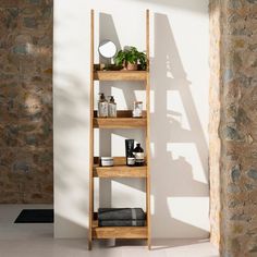 a wooden shelf filled with lots of items next to a brick wall in a room