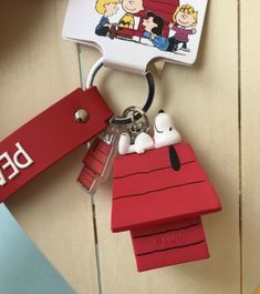 a keychain that is shaped like a house and has peanuts on the roof