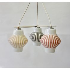 three different colored striped vases hanging from a light fixture with cords attached to them