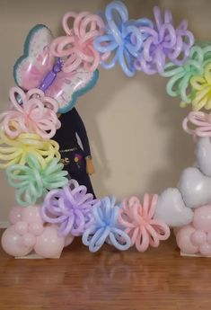 a bunch of balloons that are in the shape of a wreath on a wooden table