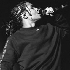 a man with dreadlocks singing into a microphone