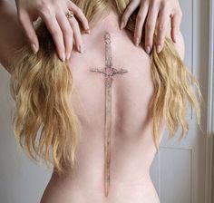 a woman with a cross tattoo on her back