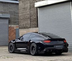 a black sports car parked in front of a garage