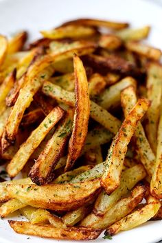 a white plate topped with french fries covered in seasoning