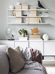 a living room filled with furniture and bookshelves next to a wall mounted clock