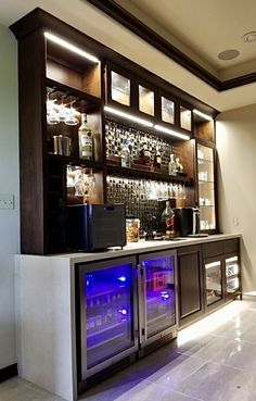 a home bar with built - in wine coolers and liquor bottles