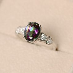 This halo ring features a 7*9mm oval cut mystic topaz and sterling silver finished with rhodium. Customization is available. It is made by hand, and it will take about 7 days to finish the ring after your payment is completed. Main stone: Mystic topaz Mystic topaz weight: Approx 2.00 ct Metal type: sterling silver / 14k gold Accent stone: cz Customization is available, I also can make it with 14k solid gold (white or yellow or rose) and diamond accent stone, just feel free to contact me. Any que Rainbow Topaz, Mystic Topaz Ring, Ring Heart, Mystic Topaz, Gold Accent, Halo Ring, Halo Rings, Topaz Ring, Gold Accents