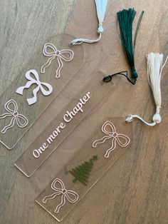 three clear acrylic plaques with green ribbon and bows on them sitting on a wooden table