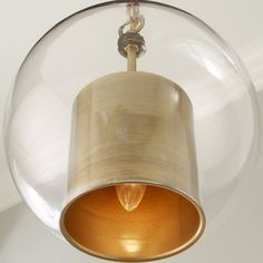 a light hanging from a ceiling fixture with a glass ball on it's side