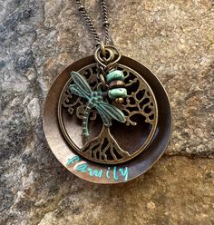 This necklace is composed of high-quality natural brass. It is hand stamped with “family” at the bottom. A filagree tree of life hangs in the center along with a verdigris dragonfly and turquoise colored Howlite stone beads. if you would like something other than family stamped at the bottom, I can certainly do that as long as it fits. Just add it to the comments at check out. The disc measures 1.25 inches and hangs on an adjustable 18 to 20 inch bronze satellite chain. This is a great personali Personalized Metal Bohemian Necklaces, Personalized Metal Bohemian Necklace, Bohemian Green Engraved Necklace, Bohemian Stamped Turquoise Necklace, Bohemian Green Stamped Jewelry, Bohemian Stamped Round Pendant Necklace, Personalized Bohemian Jewelry For Festival, Family Tree Of Life, Family Tree Necklace