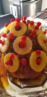 a cake with pineapples and cherries on top is sitting on a plate