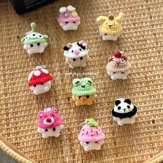 small crocheted toy animals sitting on top of a woven tablecloth next to a cell phone