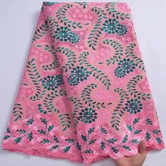 pink and green african print fabric with leaves on the bottom, in an intricate pattern