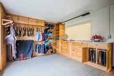 a room filled with lots of wooden cabinets and hanging items on the wall next to each other