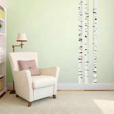 a living room with green walls and white birch tree wall decals on the wall