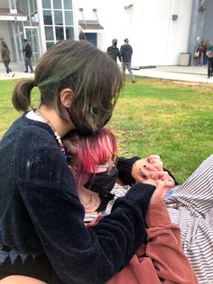 two people sitting on the ground with their faces covered by fake hair and piercings