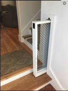 a dog door is open on the floor next to a stair case in a house