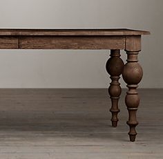 an old wooden table with two drawers on one end and three turned down legs at the bottom