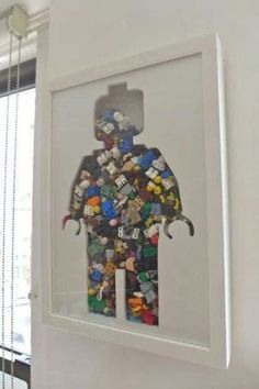 an elephant made out of legos is hanging on the wall next to a window