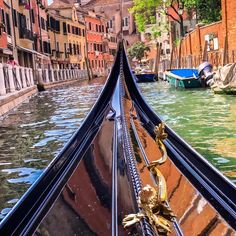 the front end of a boat traveling down a canal