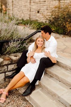 a man and woman are sitting on the steps together, posing for a photo with their arms around each other