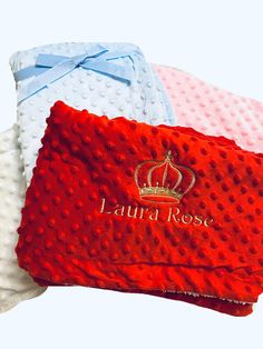 three different colored blankets with the name lauren rose on one side and crown on the other