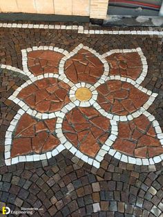 a close up of a street sign on a brick road with flowers painted on it