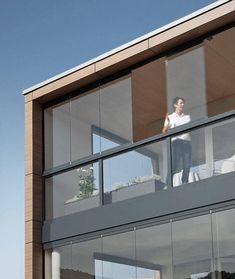 a man standing on the balcony of a modern house