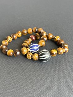 Tigers Eye Unisex Bracelet With Black & White Java Focal Bead - Etsy Artisan Hand Wrapped Black Bracelets, Everyday Artisan Beaded Bracelets, Artisan Hand Wrapped Black Bracelet, Artisan Hand-wrapped Black Bracelet, Artisan Brown Bracelets With Round Beads, Artisan Bracelet With Round Beads For Everyday, Handmade Bracelets With Round Beads, Brown Hand Wrapped Beaded Bangle Bracelet, Handmade Stretch Bracelet With Round Beads For Everyday