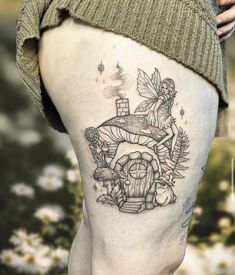 a woman's thigh with a fairy on top and flowers in the bottom half