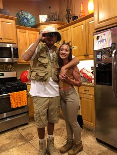 a man and woman are posing in the kitchen