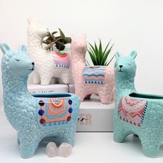 three ceramic llama planters sitting next to each other on top of a box