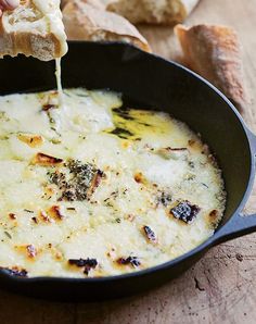 cheese being poured into a skillet with bread in the background