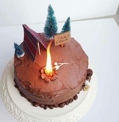 there is a cake that has been decorated with trees and a camp sign on it