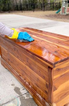 a person in blue gloves cleaning a wooden box