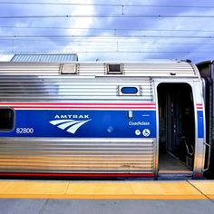 an amtrak train with its doors open at the station