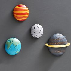 three different sized and colored balls on a gray surface