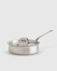 a stainless steel pan with a handle on a white background, the lid is open