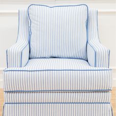 a blue and white striped chair sitting on top of a hard wood floor