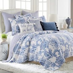 a bed with blue and white comforters in a room