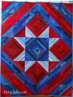 a red, white and blue quilt hanging on a wall