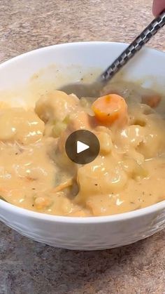 a person holding a spoon in a bowl of food