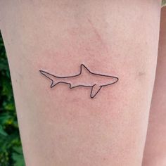 a small tattoo of a shark on the leg