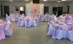 the banquet room is set up for an event with purple and white linens on tables