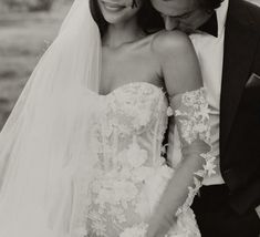 a bride and groom pose for a photo in black and white, with one holding the other's head