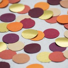 a table topped with lots of different colored confetti circles on top of each other